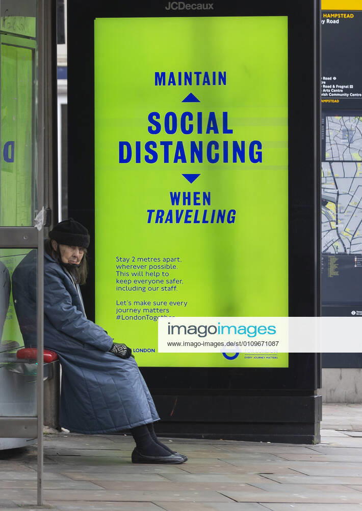 (210110) -- LONDON, Jan. 10, 2021 -- A person wearing a face mask sits next to an advertising board reading Maintain social distancing when travelling at a bus stop in London, Britain, Jan. 10, 2020. The coronavirus-related deaths in Britain surpassed 80,000 on Saturday with another 1,035 reported in the country. ) BRITAIN-LONDON-COVID-19-CASES HanxYan