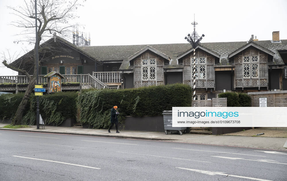 (210110) -- LONDON, Jan. 10, 2021 -- A woman walks past a closed pub in London, Britain, Jan. 10, 2021. The coronavirus-related deaths in Britain surpassed 80,000 on Saturday with another 1,035 reported in the country. ) BRITAIN-LONDON-COVID-19-CASES HanxYan