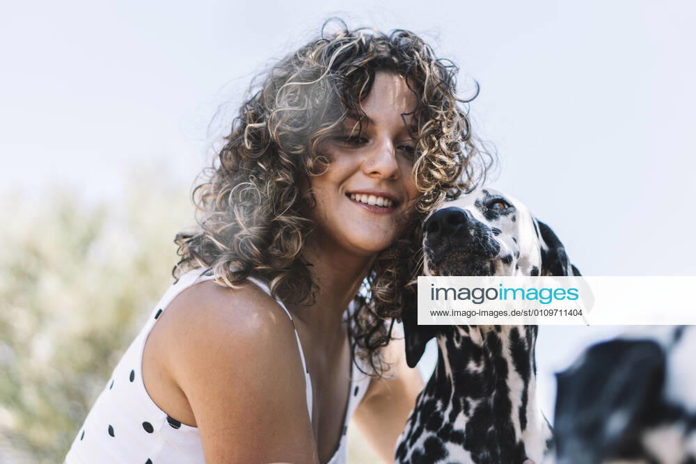 Smiling young woman with Dalmatian dog during sunny day model released Symbolfoto property released ABAYF00012