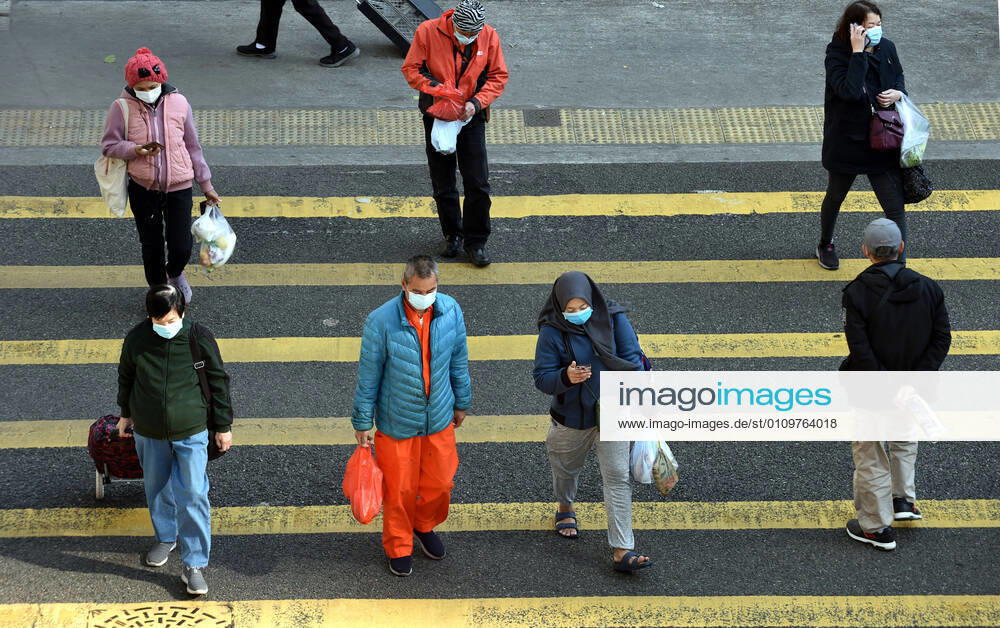 (210112) -- HONG KONG, Jan. 12, 2021 -- People wearing face masks walk across the street in south China s Hong Kong, Jan. 12, 2021. Hong Kong s Center for Health Protection (CHP) reported 60 additional confirmed cases of COVID-19 on Tuesday, taking its total tally to 9,343. All of the 60 new cases are local infections, with 13 of unknown origins. TO GO WITH Hong Kong reports 60 new COVID-19 cases, all local infections ) CHINA-HONG KONG-COVID-19-CASES (CN) LoxPingxFai