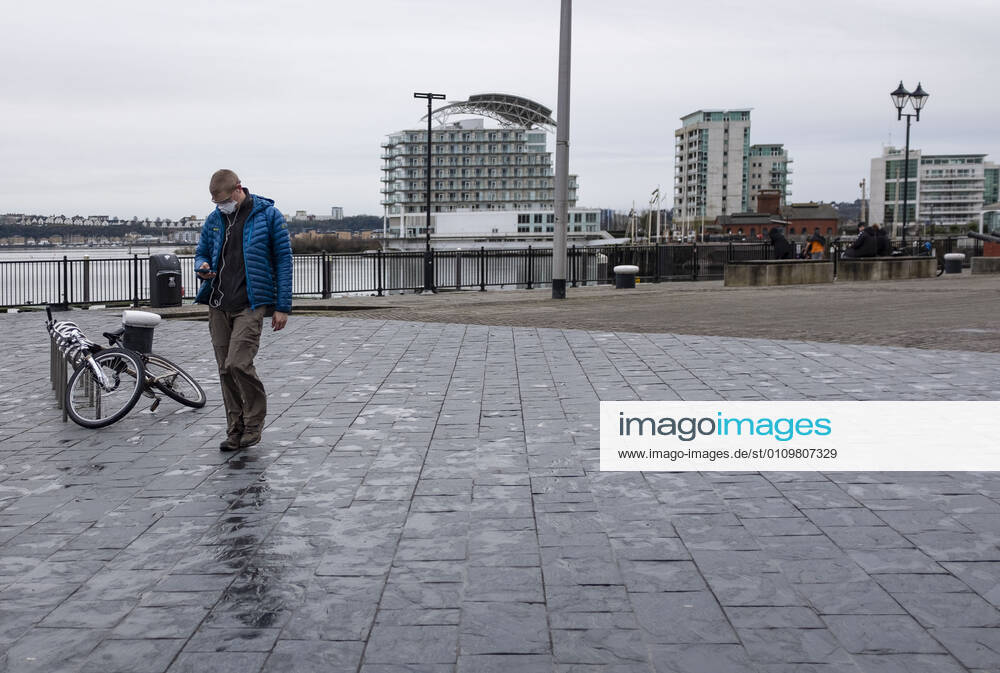 A man wearing a face mask walks around Cardiff Bay in Wales..1,332 new cases of the coronavirus have been recorded today bringing the total to 172,879 since the pandemic began. The overall death total now stands at 3,997 in Wales. The infection rate is now 403.5 cases per 100,000 people based on the seven days up to January 7. That is down on the 415 previously reported. Cardiff United Kingdom - ZUMAs197 20210112_zab_s197_008