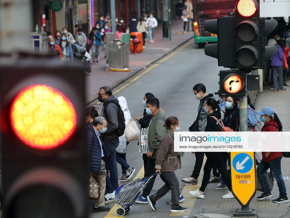 (210117) -- HONG KONG, Jan. 17, 2021 -- People wearing face masks walk across a street in Hong Kong, south China, Jan. 17, 2021. Hong Kong s Center for Health Protection (CHP) reported 55 additional confirmed cases of COVID-19 on Sunday, taking its total tally to 9,557. The new cases included 51 local infections, of which 16 had an unknown origin, according to a CHP press briefing. There were also more than 80 cases tested positive preliminarily. ) CHINA-HONG KONG-COVID-19-CASES(CN) LixGang