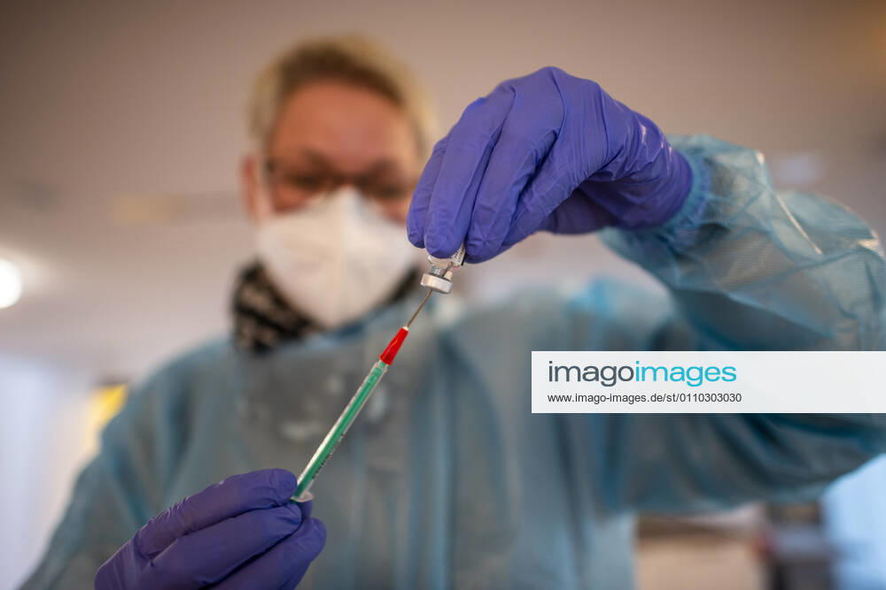 Corona-Schutzimpfung in einem Seniorenheim Eine Arzthelferin zieht eine Spritze mit dem Corona-Impfstoff auf. In einem Seniorenheim werden die Bewohner gegen eine Infektion mit dem Coronavirus geimpft. Für den Aufbau des Impfschutzes sind mit dem mRNA-Impfstoff von BioNTech zwei Impfungen im Abstand von 21 Tagen notwendig. Rietberg Nordrhein-Westfalen Deutschland