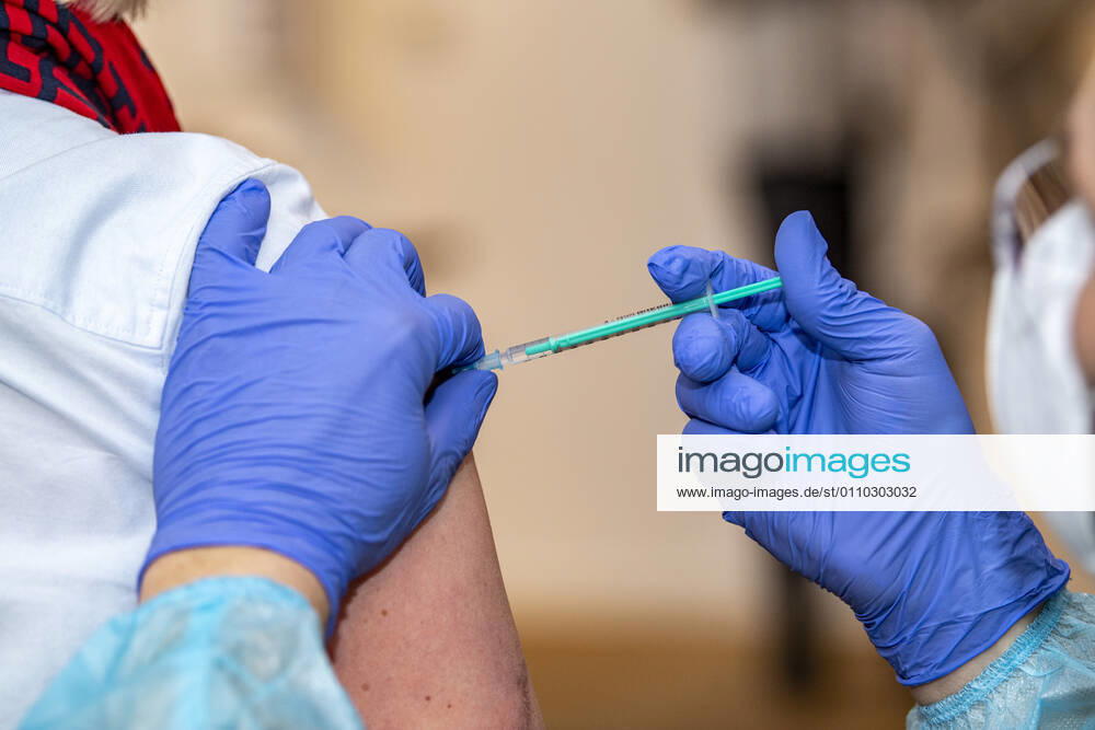 Corona-Schutzimpfung in einem Seniorenheim Ein Arzt setzt bei einer Frau die Spritze mit dem Impfstoff an. In einem Seniorenheim werden die Bewohner gegen eine Infektion mit dem Coronavirus geimpft. Für den Aufbau des Impfschutzes sind mit dem mRNA-Impfstoff von BioNTech zwei Impfungen im Abstand von 21 Tagen notwendig. Rietberg Nordrhein-Westfalen Deutschland