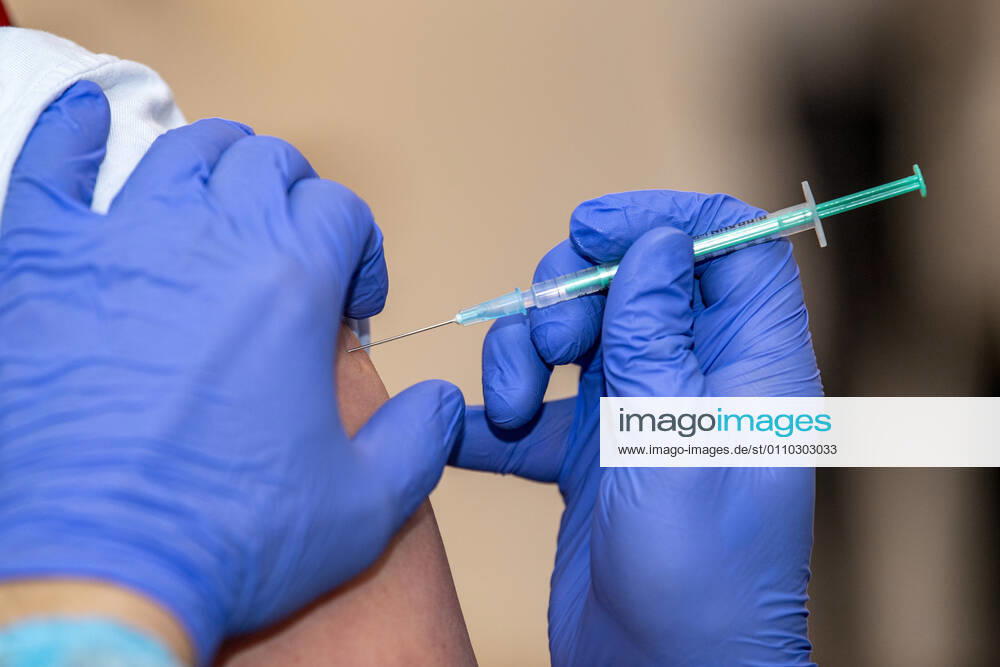 Corona-Schutzimpfung in einem Seniorenheim Ein Arzt setzt bei einer Frau die Spritze mit dem Impfstoff an. In einem Seniorenheim werden die Bewohner gegen eine Infektion mit dem Coronavirus geimpft. Für den Aufbau des Impfschutzes sind mit dem mRNA-Impfstoff von BioNTech zwei Impfungen im Abstand von 21 Tagen notwendig. Rietberg Nordrhein-Westfalen Deutschland