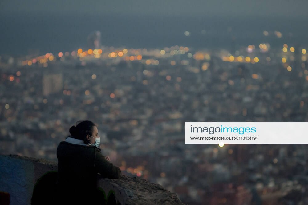A woman wearing a face mask looks over Barcelona city from the Turo de La Peira hill viewpoint. A couple kiss atop of the Turo de La Peira hill viewpoint with La Sagrada Familia and Barcelona city in the background. Data from the Spanish Ministry of Health indicate that this Tuesday in Spain there have been 404 deaths from coronavirus and 24,185 patients remain in hospitals by Covid-19. Barcelona Spain - ZUMAb137 20210119_zap_b137_003