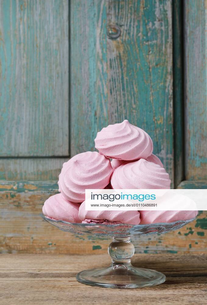 Pink meringues on wooden background. Party dessert BEW1D88CDC8