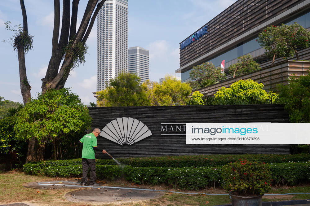 Singapur, Republik Singapur, Asien - Ein Arbeiter waessert am Mandarin Oriental Hotel Singapore in Marina Square die Pflanzen. Auf Grund der andauernden Corona-Krise verbuchen viele Hotels des Stadtstaats enorme Umsatzeinbussen, da die Hotelauslastung schwer angeschlagen ist. Die stark vom Handel abhaengige Wirtschaft der Finanzmetropole erlitt im letzten Jahr auf Grund der Corona-Pandemie die schlimmste Rezession in ihrer jungen Geschichte und verzeichnete einen Rueckgang des BIP um 5,8 Prozent.