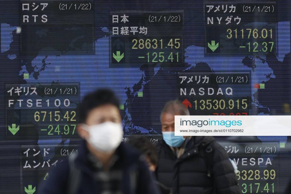 People wearing face masks to prevent the spread of the coronavirus walk past an electronic stock board showing Japan s Nikkei Stock Average, which ended down -125.41 points or -0.44 percent to close at 28,631.45 in downtown Tokyo. Tokyo Japan - ZUMAm191 20210122_zap_m191_001
