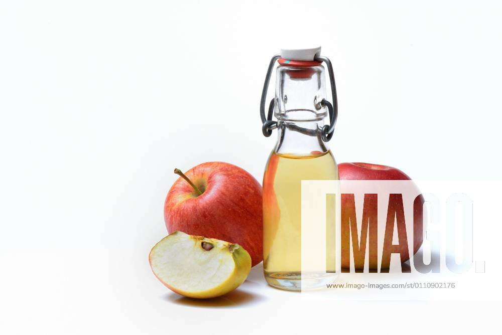 Flasche mit Apfelessig und Äpfel