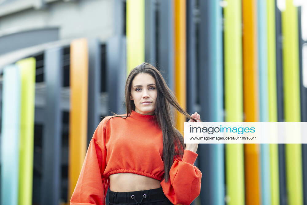 Portrait of beautiful brunette standing outdoors with hand in hair model released Symbolfoto JCCMF00786
