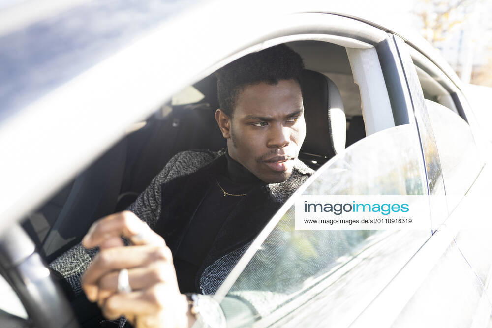 Young man driving car model released Symbolfoto JCCMF00794