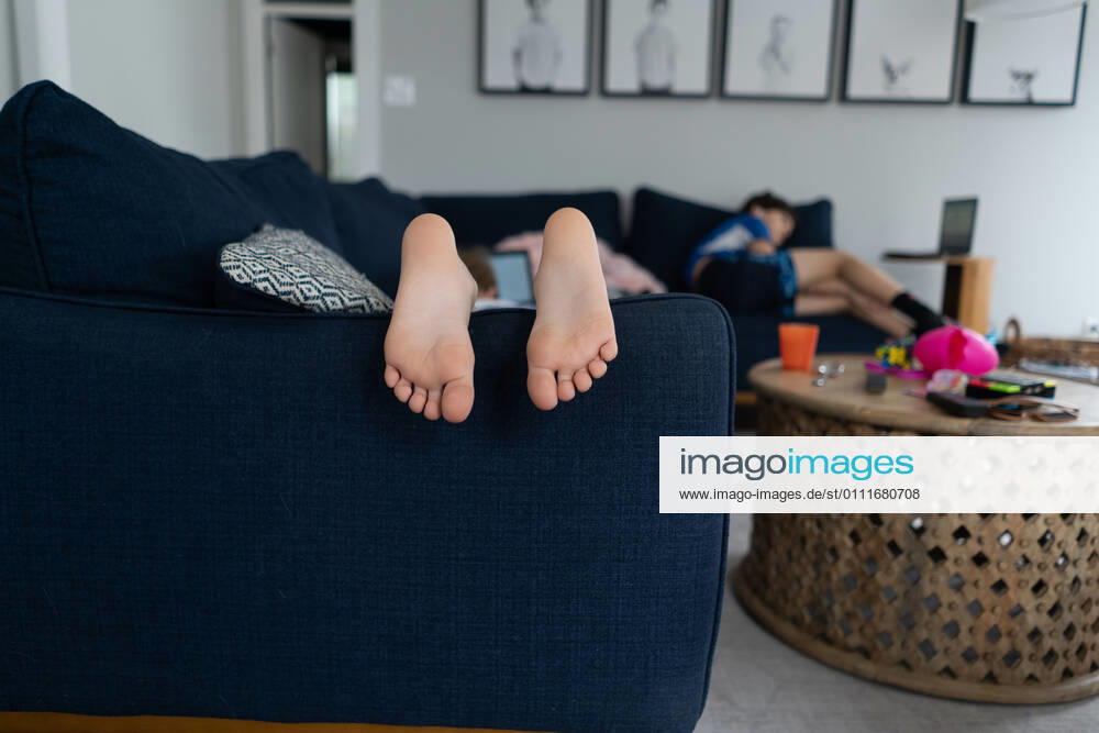 IMAGO Creative: Jahreszeit Winter, Fantasievoll drinnen spielen feet and toes of child laying on couch with brother in background La Grange Park, IL, United States CR_JERE210106-586958-01 ,model released, Symbolfoto ,property released