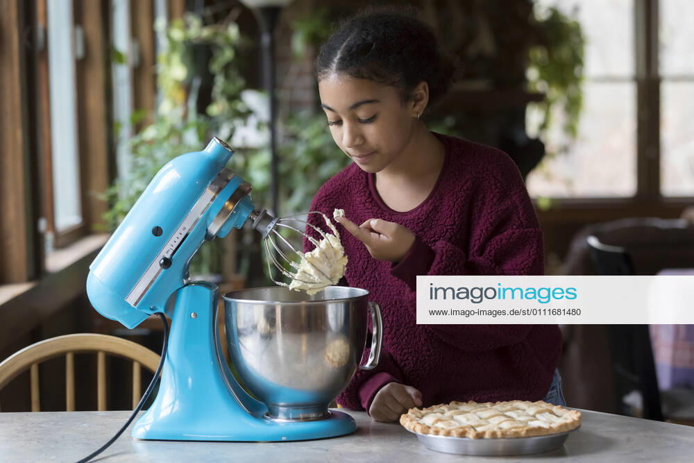 IMAGO Creative: Haushaltsgeräte - Küchenmaschine A biracial eleven year-old girl sneaks a taste of whipped cream Brewster, MA, United States CR_JUCU210129B-590322-01 ,model released, Symbolfoto