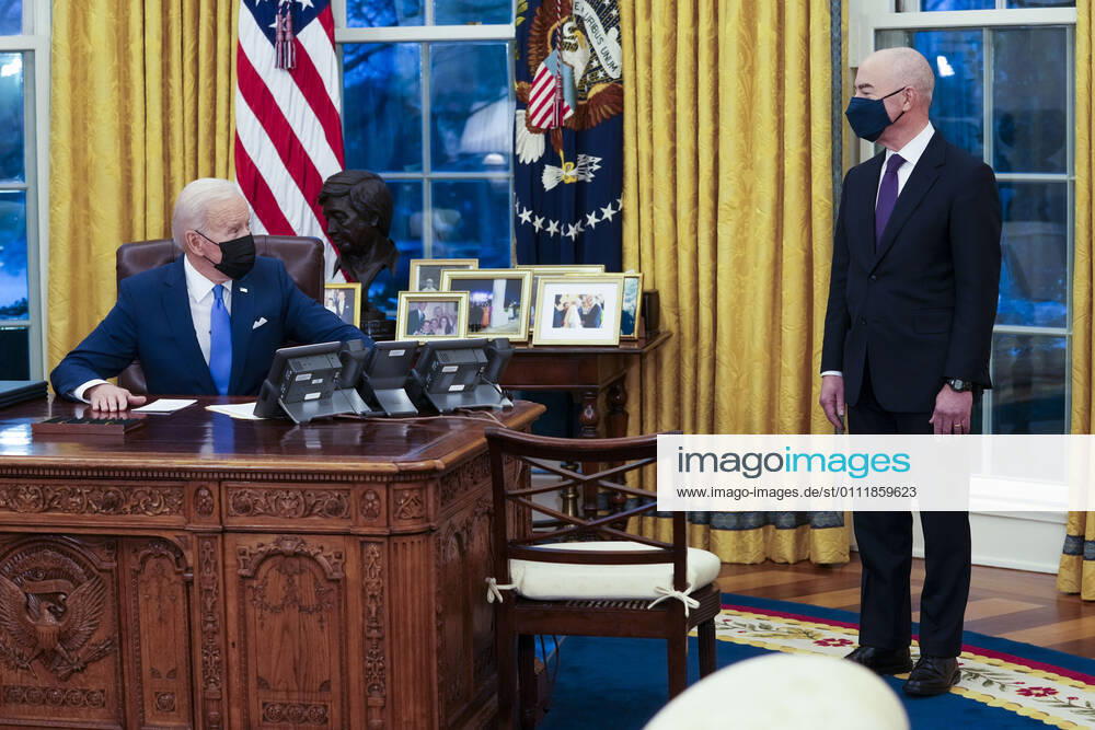United States President Joe Biden looks towards US Secretary of Homeland Security Alejandro Mayorkas before signing executive orders advancing his priority to modernize our immigration system in the Oval Office of the White House in Washington, DC, Tuesday