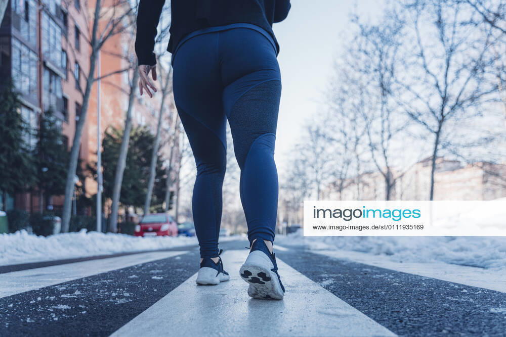Attractive young brunette woman running through the city after a big snow storm Madrid, Community of Madrid, Spain CR_IGMA210203-630079-01 ,model released, Symbolfoto