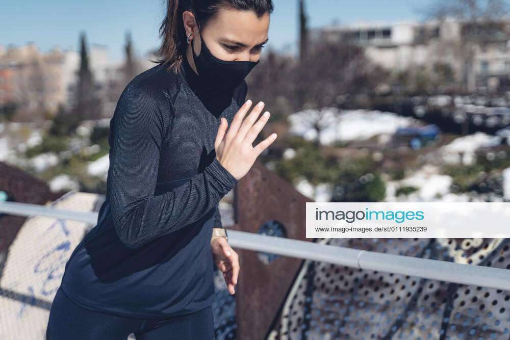 Attractive young brunette woman running through the city after a big snow storm Madrid, Community of Madrid, Spain CR_IGMA210203-630100-01 ,model released, Symbolfoto