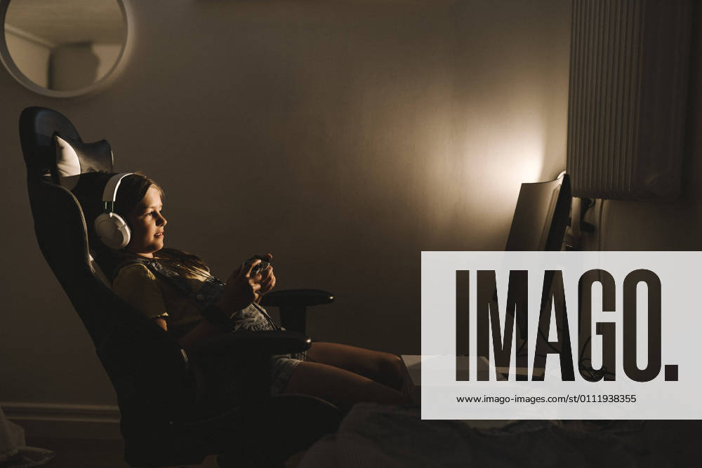 IMAGO Creative, Lifestyle, Gaming Pre-adolescent girl playing video game over television at home Sweden, Gothenburg, model released, property released