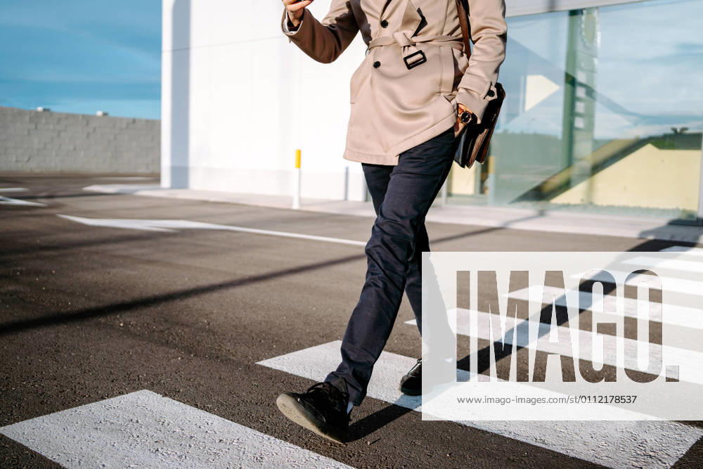 IMAGO Creative: Kreative Renaissance -- der junge Entrepreneur Crop unrecognizable male entrepreneur in stylish outfit walking on crosswalk on sunny day in city