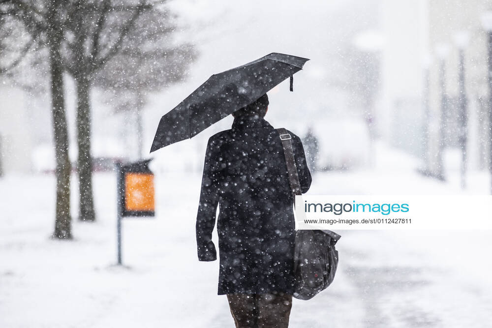 Ein Mann mit Regenschirm, aufgenommen waehrend starken Schneefalls in Berlin, 08.02.2021. In der nordlichen Haelfte Deutschlands gibt es teils unwetterartige Schneefaelle und zweistellige Minusgrade. Berlin Deutschland