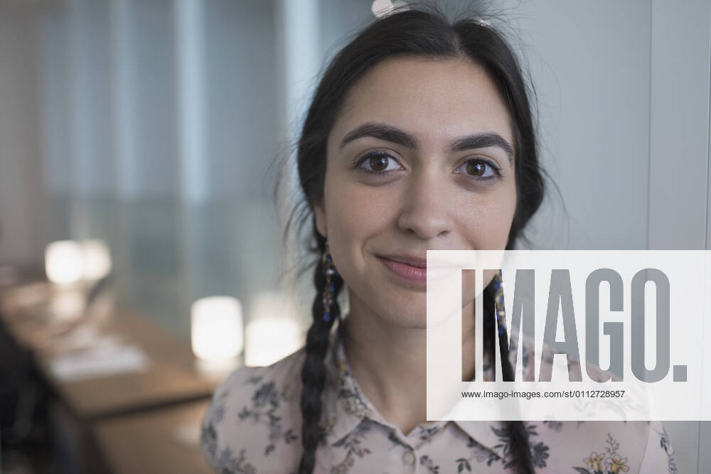 Young woman working in office looking at camera. model release HEX17003_TP_0577
