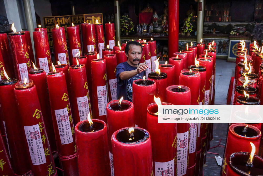A man lights candles at the Dharma Ramsi Temple during the Lunar New Year celebrations..The Lunar New Year, also known as Spring Festival, falls on 12 February 2021, marking the beginning of the Year of the Ox. Bandung Indonesia - ZUMAs197 20210212_zaa_s197_068
