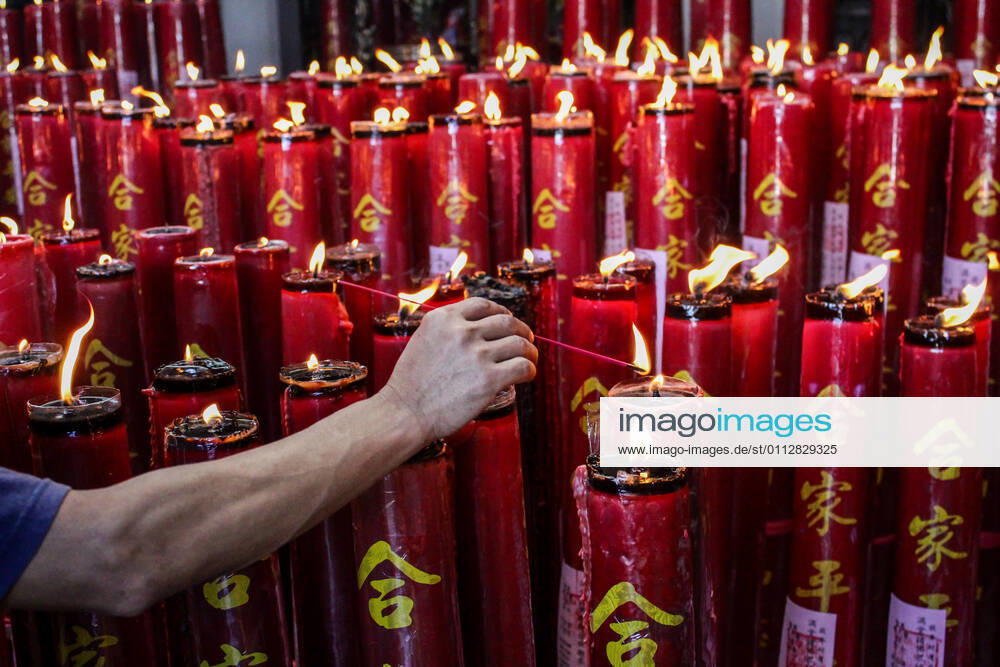 A man lights candles at the Dharma Ramsi Temple during the Lunar New Year celebrations..The Lunar New Year, also known as Spring Festival, falls on 12 February 2021, marking the beginning of the Year of the Ox. Bandung Indonesia - ZUMAs197 20210212_zaa_s197_076