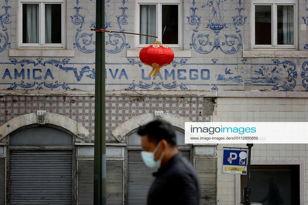 A men wearing a face mask walks under a red lantern that were put up for the Chinese New Year marking the Year of the Ox at Almirante Reis avenue in Lisbon, Portugal on February 12, 2021. This year, with restrictions imposed by the state of emergency in Portugal due to the COVID-19 pandemic, online broadcasting replaces Chinese New Year celebrations, such as the traditional parade with dragons, snakes and acrobats, which attracts hundreds of people every year to the Almirante Reis avenue, however the traditional red lanterns adorn the avenue, to mark the event. Lisbon Portugal - ZUMAf123 20210212_zap_f123_001