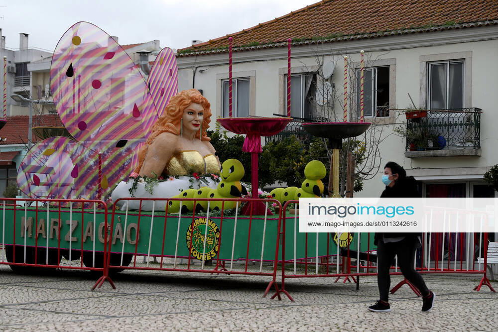 A woman wearing a facial protective mask walks by a carnival float on display in Loures, on the outskirts of Lisbon, Portugal, on February 16, 2021. Portugal s carnival parades and festivities had to be canceled as part of ongoing lockdown measures against COVID-19 pandemic, but some municipalities have adapted and asked revelers to party in their windows or online. Lisbon Portugal - ZUMAf123 20210216_zap_f123_005