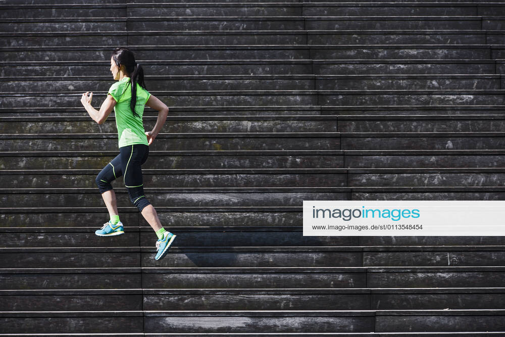 Woman running up wooden stairs in Paris France, Île-de-France, Paris CR_THHE210219-656433-01 ,model released, Symbolfoto