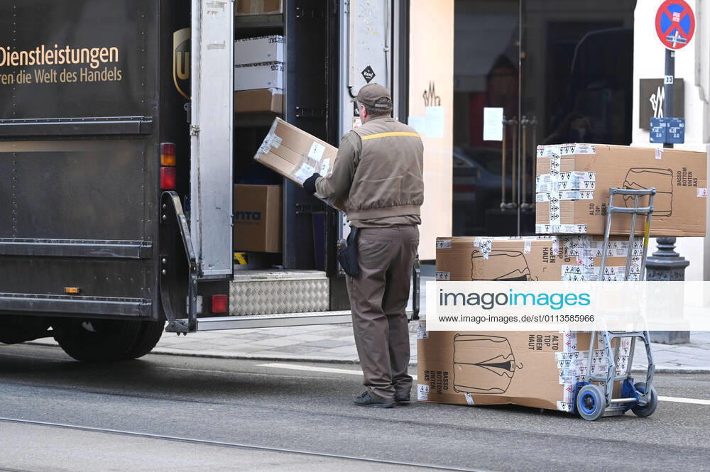 UPS Paketzusteller bei der Arbeit,Paketbote,United Parcel in Innenstadt in Muenchen. Service,Paket,Pakete,Paketdienst,liefern,zustellen, entladen,versenden,Transporter,Sackkarre.