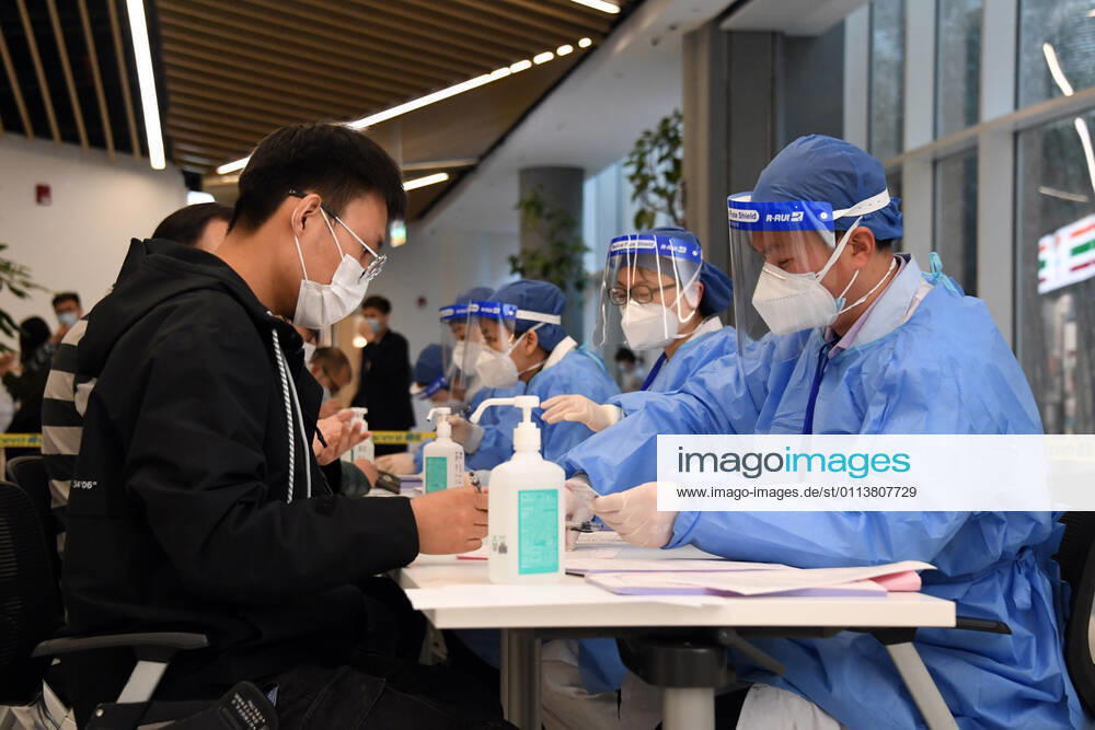 (210222) -- BEIJING, Feb. 22, 2021 -- A staff member (front, L) signs a letter of informed consent at a temporary COVID-19 vaccination site at a company in the ZPark Phase 2 in Haidian District of Beijing, capital of China, Feb. 22, 2021. It is expected to take two days to complete the vaccination of more than 3,800 employees of the enterprise. ) CHINA-BEIJING-HAIDIAN-VACCINATION (CN) RenxChao