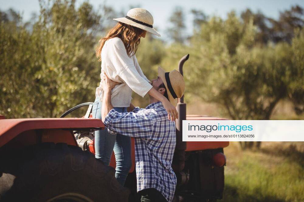 Young couple looking at each other while standing by tractor Young couple looking at each other while standing by tractor at olive farm, model released, , property released, Cape Town, South Africa, 22.03.2017, 1008932.jpg, couple, looking, standing, tractor, olive farm, farm, lifestyle, leisure, casual, white, checked pattern, girlfriend, boyfriend, sun hat, protection, safety, holding, heterosexual couple, together, bonding, love, tree, nature, joy, fun, sunlight, land vehicle, agricultural machinery 30s, Mid Adult, Woman, Female, Hispanic, 20s, Young Adult, Man, Male, Caucasian, 30-34 Years, Mid Adult Women, Hispanic Ethnicity, 25-29 Years, Young Men, Caucasian Ethnicity Outdoors,Side view,Focus on Foreground,Day