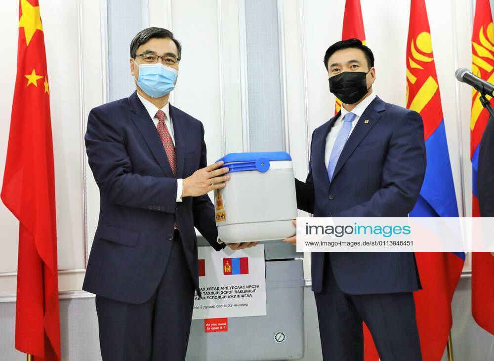 (210223) -- ULAN BATOR, Feb. 23, 2021 -- Chinese Ambassador to Mongolia Chai Wenrui (L) delivers samples of COVID-19 vaccines donated by China to Mongolian Deputy Prime Minister Sainbuyan Amarsaikhan during a handover ceremony at the Chinggis Khaan International Airport in Ulan Bator, Mongolia, Feb. 23, 2021. Mongolia on Monday night received 300,000 doses of Sinopharm COVID-19 vaccine donated by China. ) MONGOLIA-ULAN BATOR-CHINA DONATED-COVID-19 VACCINES Asigang