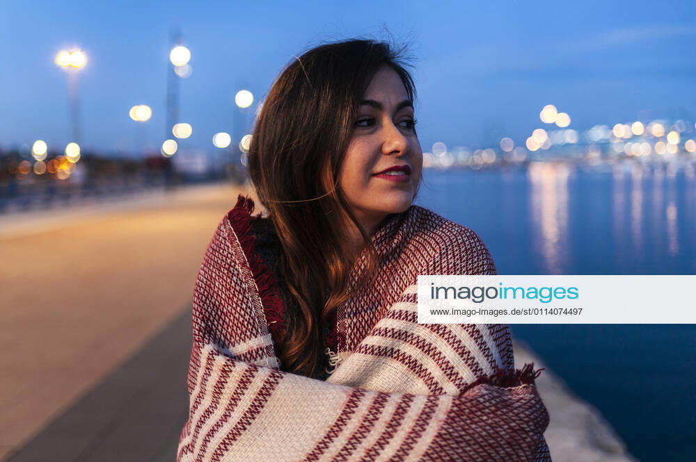 Young woman wrapped in scarf day dreaming by bay of water model released Symbolfoto JMPF00866
