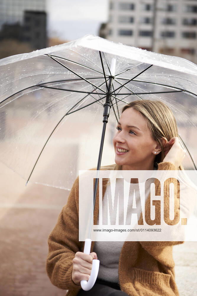 IMAGO Creative: Neue Frühlingsmode Thoughtful woman with umbrella looking away during rainy season model released Symbolfoto VEGF03889