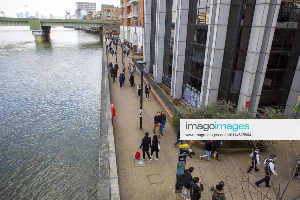 People walk along the river bank on a sunny day amid covid19 pandemic in London..The UK has reported another 345 coronavirus deaths and 8,523 new cases, while more than 19 million people have received their first vaccine dose. London United Kingdom - ZUMAs197 20210227_zaa_s197_142