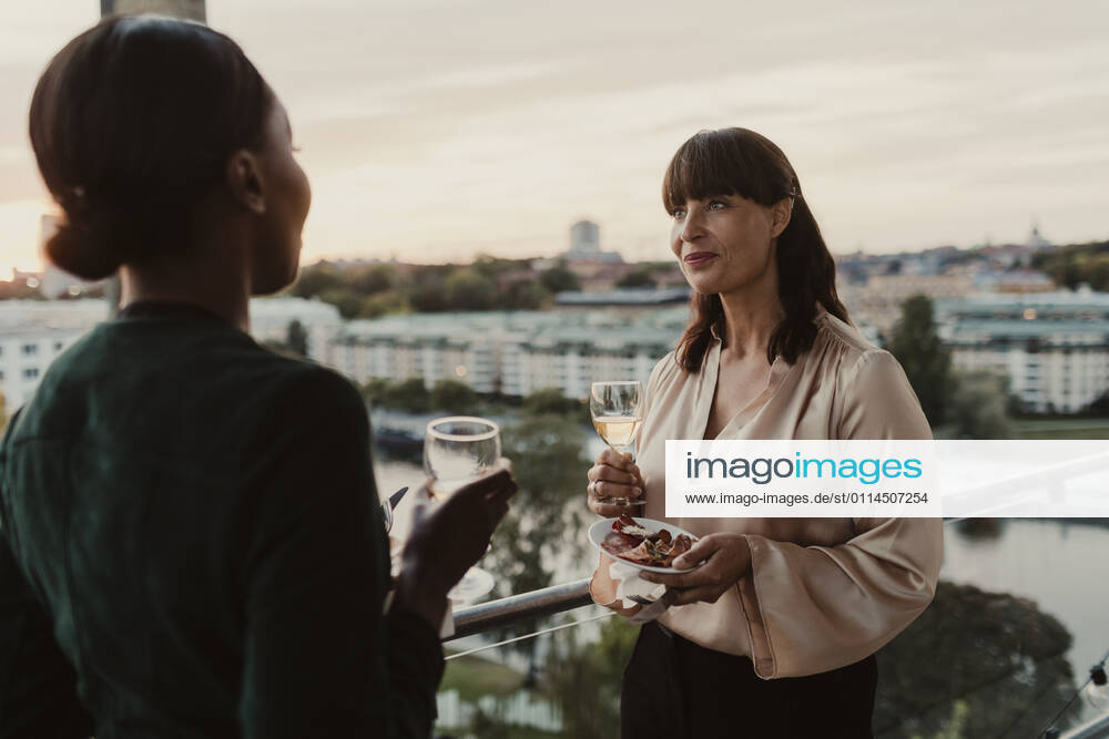 Smiling female colleagues with champagne in office during party Sweden, Stockholm, model released, property released