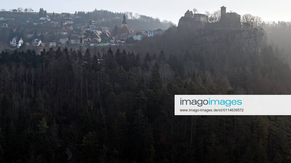 Deutschland,Sachsen, Sächsische Schweiz, Hohnstein: Blick auf die Burg Hohnstein im Schein der aufgehenden Sonne. Die einzige bis heute erhaltene rechtselbische Burg in der Sächsischen Schweiz wurde vermutlich im 12. Jahrhundert als böhmische Grenzfeste zur Markgrafschaft Meißen gebaut. Heute befinden sich hier unter anderem ein Museum und eine Gedenkstätte. Die Burg liegt malerisch unmittelbar am Nationalpark Sächsische Schweiz auf einem Felssporn über dem Polenztal. Tausende Touristen besuchen Burg und Stadt in der Feriensaison.