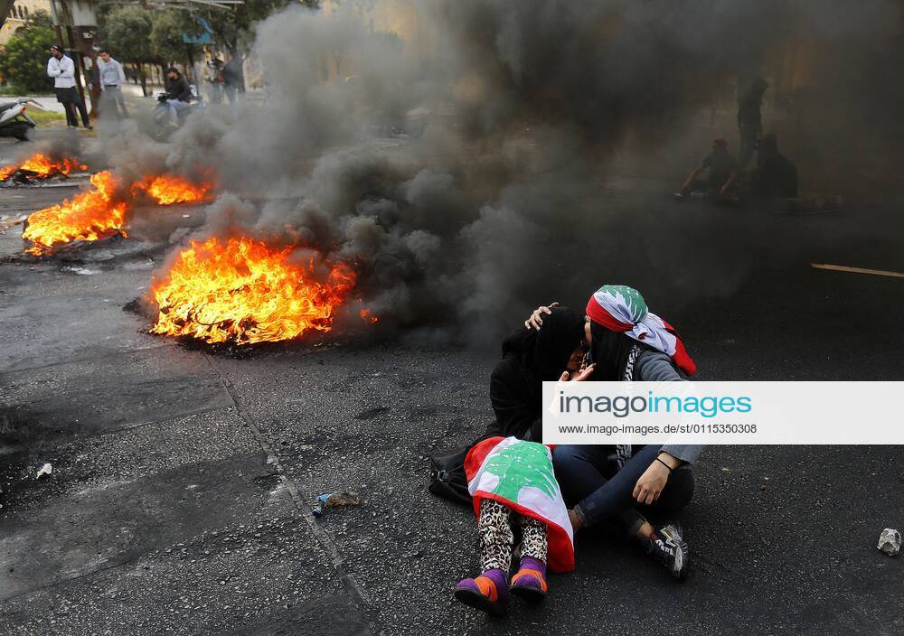 Lebanese protester kisses the head of an elderly female protester during a protest against the power cuts, the high cost of living, the low purchasing power of the Lebanese pound, Beirut, Lebanon, March 12, 2021. Protesters in all Lebanon burned tires and garbage where they blocked all main roads. State-provided electricity in Beirut has reached record-low levels that seem insurmountable for financial reasons Beirut Lebanon - ZUMAap3_ 20210408_zaf_ap3_001