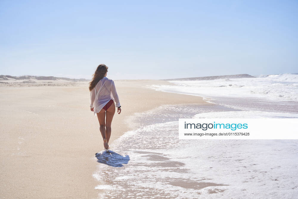 Girl from behind walking on a lonely and heavenly beach, enjoying freedom. Aveiro, Aveiro District, Portugal CR_OSPE210312-662058-01 ,model released, Symbolfoto