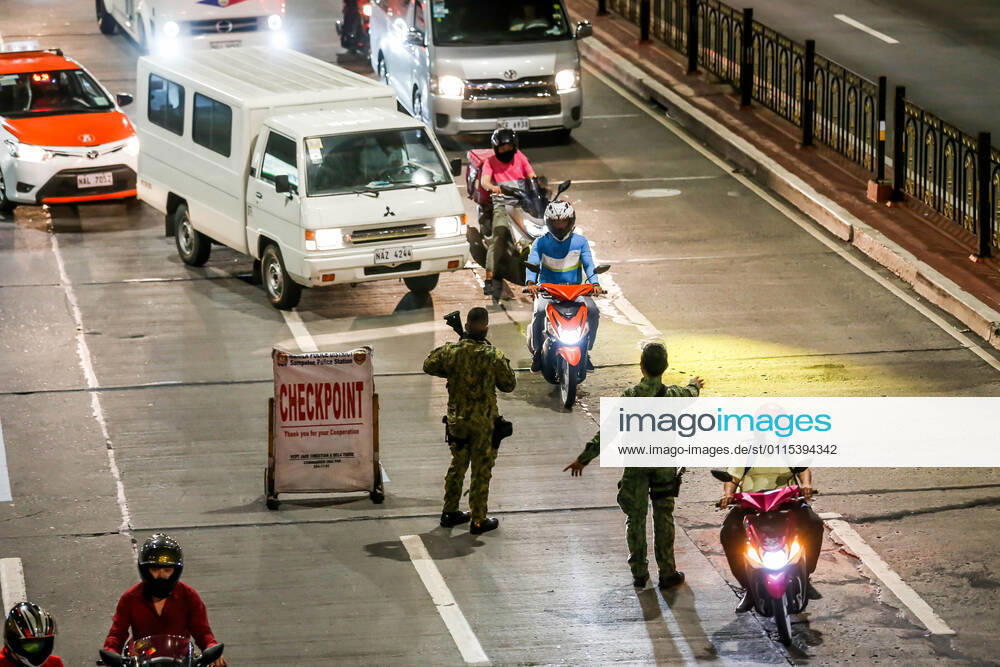 Coronavirus auf den Philippinen, Polizei überwacht Ausgangssperre (210315) -- MANILA, March 15, 2021 -- Policemen work at a checkpoint for passing motorists during the implementation of strict quarantine measures in Manila, the Philippines on March 15, 2021. Metro Manila, home to about 13 million people, started imposing strict quarantine measures again on Monday to contain a recent surge of coronavirus infections. The Philippines Department of Health (DOH) reported on Monday that 5,404 new coronavirus disease (COVID-19) infections, the highest daily tally in seven months, bringing the total number of confirmed cases in the country to 626,893. ) PHILIPPINES-MANILA-COVID-19-QUARANTINE MEASURES RouellexUmali