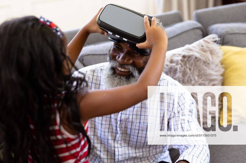Senior African American man and his granddaughter Using vr headset Senior African American man and his granddaughter enjoying their time at home together, sitting on a couch, wearing a VR headset, model released, , property released, Cape Town, South Africa, 19.02.2020, 1340098.jpg, people,family,grandfather,granddad,granddaughter,childhood,together,closeness,interacting,sitting,couch,happy,smiling,wearing,using,vr,virtual reality,headset,connection,communication,real people,home,house,domestic life,lifestyle,enjoying,free time,leisure,relaxing,weekend,summer,sunny,love Child,Girl,Female,Mixed-Race,Mid Adult,Man,Male,Black Indoors,Front view,Looking at camera,Day,Half length