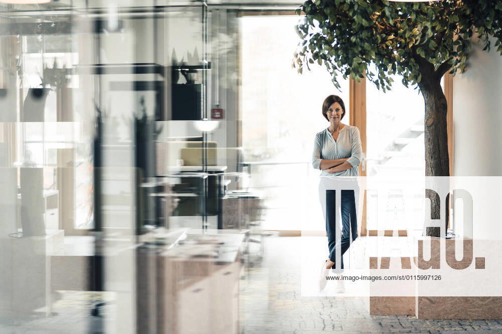 Confident female entrepreneur with arms crossed in office model released Symbolfoto property released JOSEF03669
