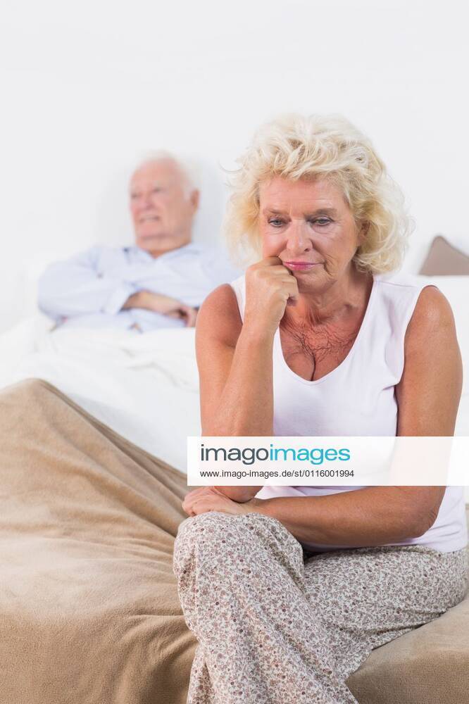 Discouraged old woman sitting Discouraged old woman sitting on the bed with old man in background, model released, Majorca, Spain, 15.10.2012, 164742.jpg, home, house, household, homey, apartment, domicile, abode, bedroom, bed, duvet, pyjamas, nightwear, resting, comfortable, couple, relationship, together, leaning, white hair, depressed, discouraged, unsmiling, weary, sad, upset, unhappy, thinking 80s, Mature Adult, Man, Male, Caucasian, 60s, Woman, Female, 80 Plus Years, Senior Men, Caucasian Ethnicity, 60-64 Years, Senior Women Indoors,Front view,Focus on Foreground,Day