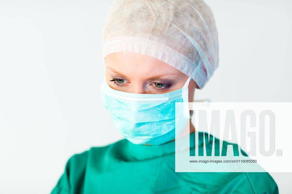 IMAGO Creative: NGO, Rehabilitation und Gesundheitswesen Pretty female surgeon with a mask Pretty female surgeon with a mask, model released, Cork, Ireland, 2009-08-15T23:00:00.000Z, 25507.jpg, adult, attractive, background, beautiful, beauty, blue, chart, complexion, cute, doctor, face, fgorgeous, hair, hands, happy, head, holding, isolated, joy, joyful, medical, model, notes, nurse, patient, pen, portrait, posing, pretty, red, redhead, school, scrubs, skin, smooth, standing, stethoscope, taking, white, working, writing 20s, Young Adult, Woman, Female, Caucasian, Caucasian Appearance, 20-24 Years, Young Women
