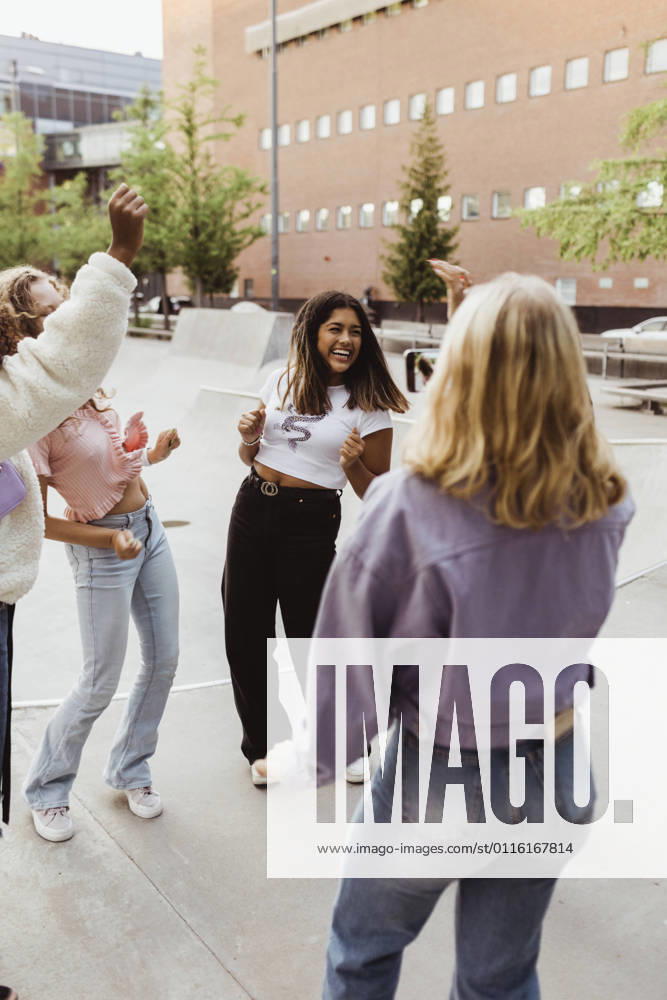 Happy female teenager friends dancing at skate park Sweden,Stockholm, model released
