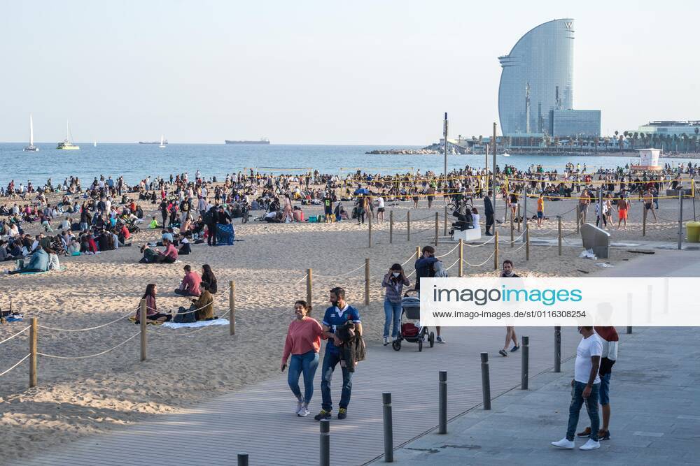 People seen on Barceloneta beach promenade..The Barceloneta Beach in Barcelona is full in the 2021 beach season. In a state of alarm due to the corona virus pandemic, in Catalonia, the use of facemasks and safety distance is mandatory in all public spaces to contain the spread of COVID- 19 pandemic. Barcelona Spain - ZUMAs197 20210403_zab_s197_026
