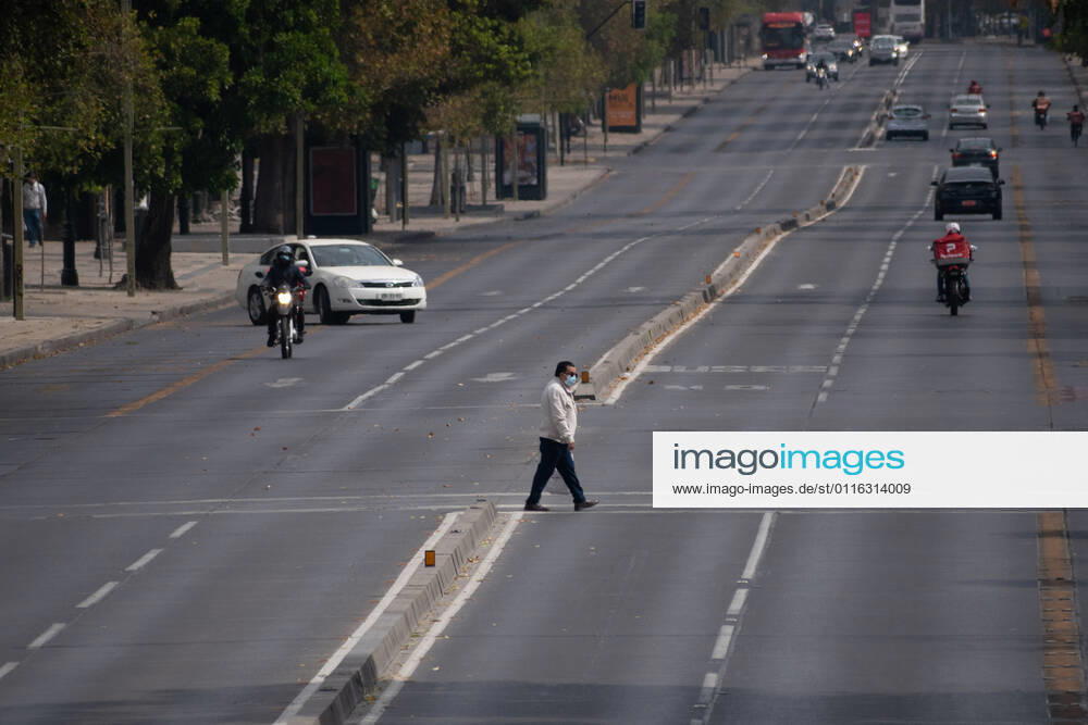 A man with a mask crosses a main street in Santiago, in the middle of the total quarantine decreed last week for the Metropolitan Region. Santiago Chile - ZUMAb332 20210404_zip_b332_019