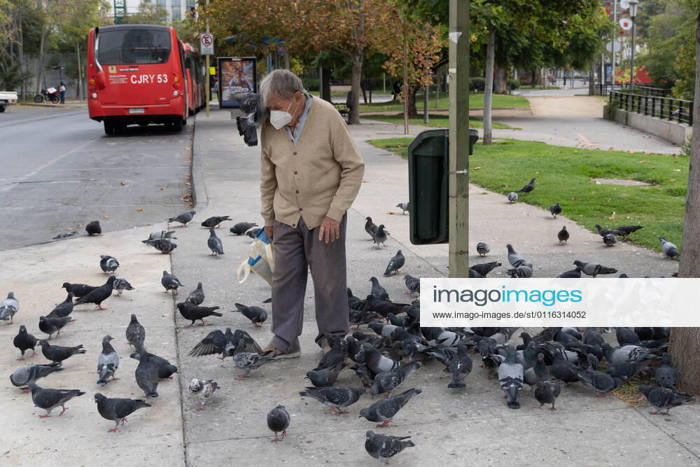 A man with a mask feeds pigeons, amid the total quarantine decreed last week for the Metropolitan Region. Santiago Chile - ZUMAb332 20210404_zip_b332_035